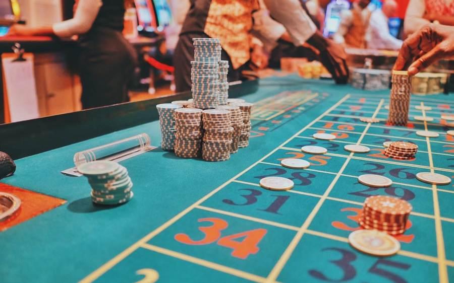 Meja roulette dengan keping taruhan tersebar di atas kain hijau